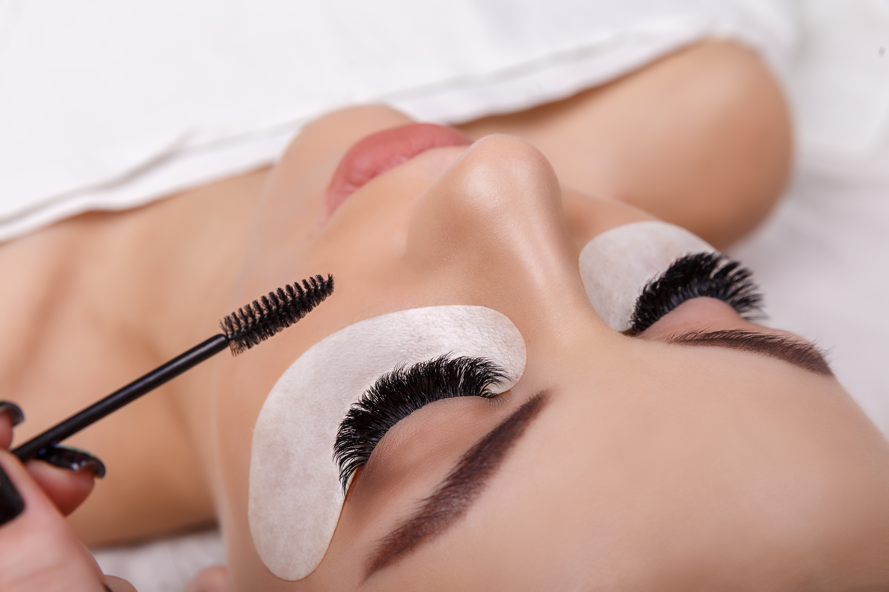 Eyelash Extension Procedure. Woman Eye with Long Eyelashes. Close up, selective focus. Fashion, russian volume